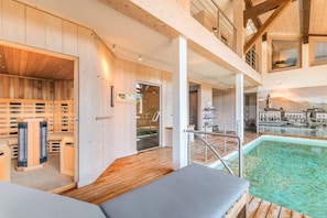 A spa area with wooden walls, a sauna, and a pool. - Chalet X – 15 people – Montriond (Montriond)
