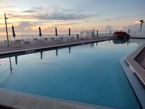 Ein Swimmingpool mit freiem Blick auf den Sonnenuntergang im Hintergrund.