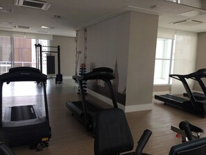 A gym with treadmills, a stationary bike, and a rowing machine. - Studio London near Paulista w/ Parking LA804 (São Paulo)