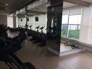A gym with stationary bikes and treadmills, large windows, and a modern design. - Studio London near Paulista w/ Parking LA804 (São Paulo)