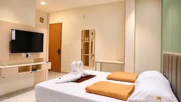 Ein Hotelzimmer mit Bett, Fernseher, Kleiderschrank und Spiegel.