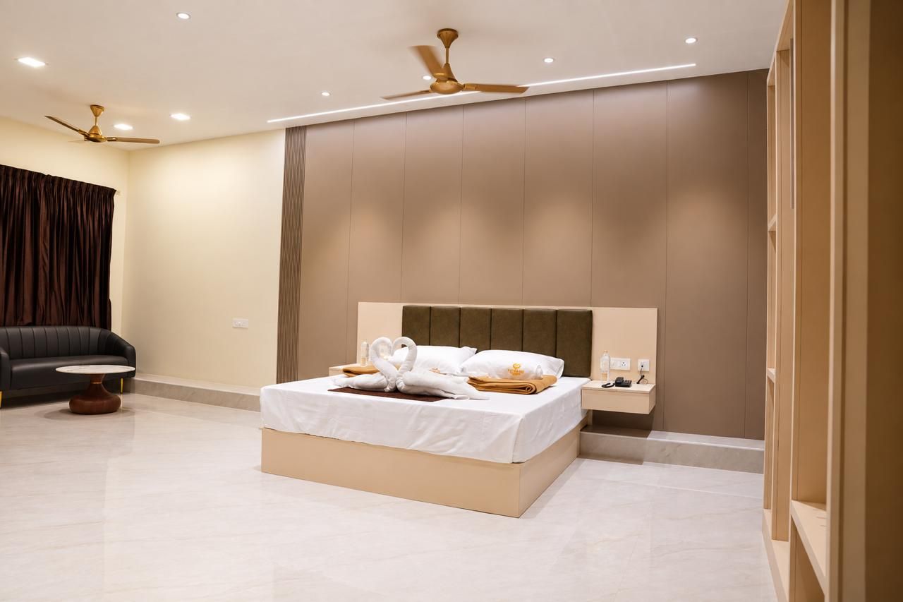 Egy modern szállodai szoba, amelyben található egy ágy, egy éjjeliszemélyzet és egy mennyezeti ventilátor.