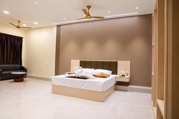 A modern hotel room with a bed, bedside table, and a ceiling fan.