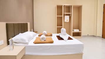 Ein Hotelzimmer mit Bett, Nachttisch, Kleiderschrank und Badebereich.
