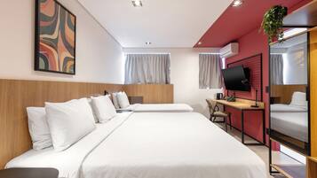 Ein Hotelzimmer mit einem großen Bett, einem Schreibtisch, einem Sessel, einem Fernseher und einer Pflanze.