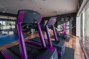 A gym with treadmills, exercise bikes, and a mirrored wall. - Casa Sirenas (Cabo San Lucas)