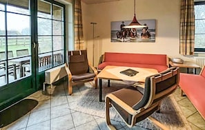 A room with a sofa, chairs, a table, a painting, and a view through a window. - 3 bedroom beautiful home in Ribnitz-Damgarten (Ribnitz-Damgarten)