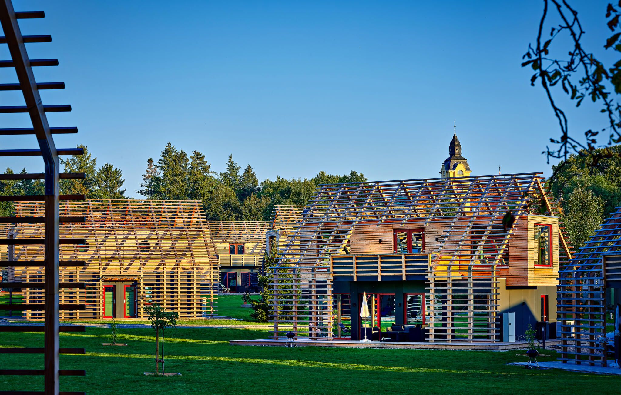A modern building with a sloped roof and a visible tower.