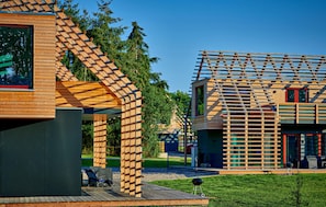 Ein modernes Holzhaus mit geneigtem Dach und einem Balkon.