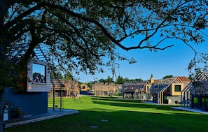 Bairro residencial com casas modernas, gramado e céu azul límpido.