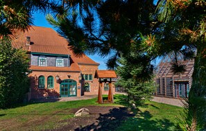 A traditional brick building with a red-tiled roof, a wooden porch, and a small tree in the foreground. - Pet friendly home in Kuhlen-Wendorf with house a panoramic view (Kuhlen-Wendorf)