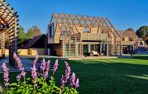 A modern house with a wooden lattice facade, a well-maintained lawn, and a clear sky. - 2 bedroom awesome home in Kuhlen-Wendorf (Kuhlen-Wendorf)