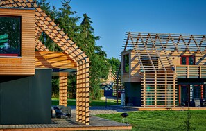 Ein modernes Holzhaus mit geneigtem Dach und einem Balkon.
