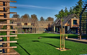 A modern building with a wooden facade, a green lawn, and a clear sky. - 2 bedroom pet friendly apartment in Kuhlen-Wendorf (Kuhlen-Wendorf)