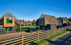 Ein modernes Gebäude mit Holzfassade und einem geparkten Auto davor.