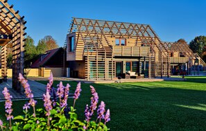 Een modern huis met een houten latticewerk gevel, een verzorgd gazon en een heldere lucht.