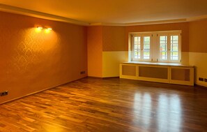 A room with hardwood flooring, a window with multiple panes, and a wall-mounted light fixture. - Awesome apartment in Kuhlen-Wendorf with sauna (Kuhlen-Wendorf)