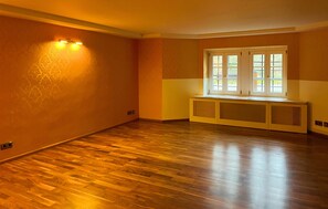 An empty room with hardwood flooring, a window with blinds, and a wall-mounted light fixture. - 42 - Ferienwohn Sissi & Franzl (Kuhlen-Wendorf)