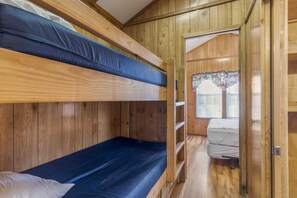 A bunk bed room with wooden walls and a window with blinds. - Bluff River View Cabin - Sleeps 4 to 6 guests. (Gore)