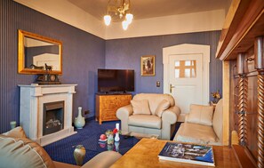 A living room with a fireplace, television, and comfortable seating. - Stunning apartment in Kuhlen-Wendorf with sauna (Kuhlen-Wendorf)