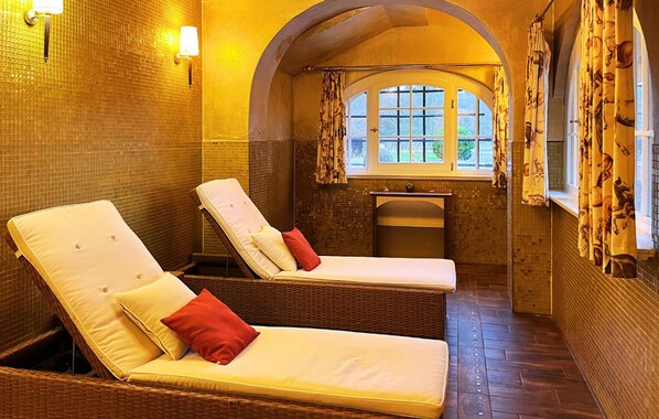 Une salle de spa équipée de deux fauteuils inclinables, d’un petit lavabo et d’une fenêtre avec des rideaux.