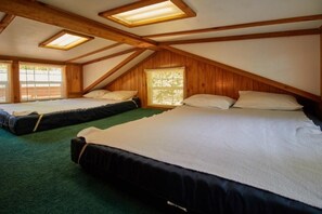 A room with two beds, wooden beams, and skylights. - Two Room Trout Pond Cabin - Sleeps 6 to 8 guests, ADA Accessible (Gore)