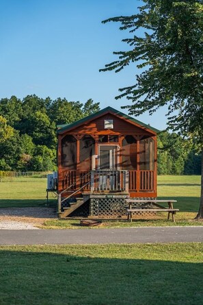 A small wooden cabin with a porch and a staircase leading to the entrance. - Double Deluxe Cabin - Sleeps 8 to 10 guests. (Gore)