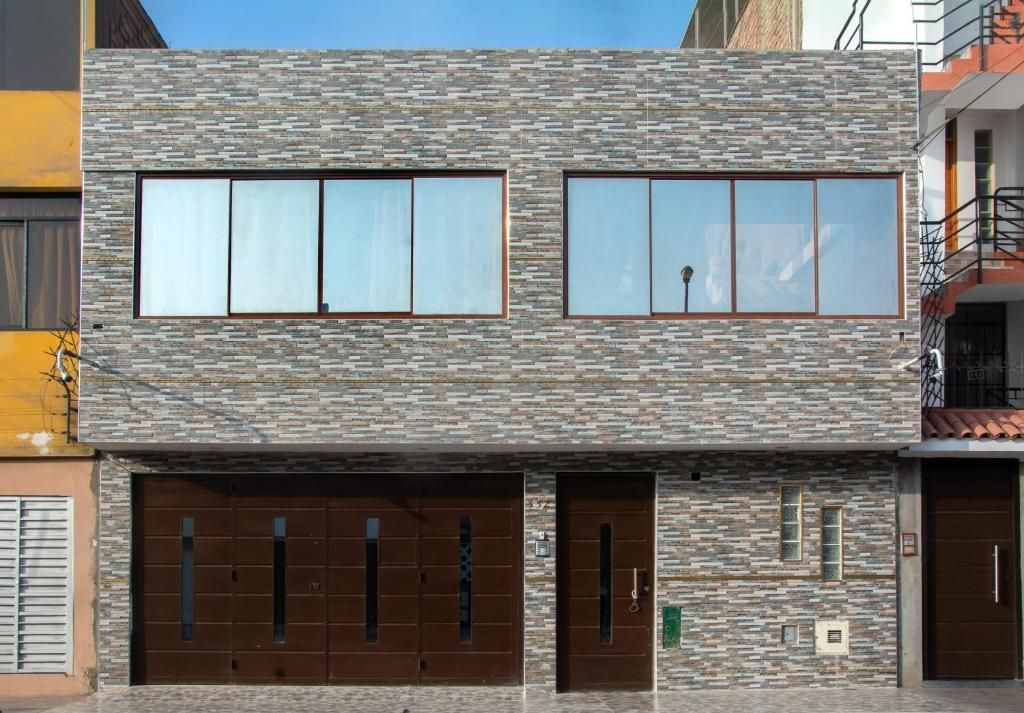 A modern two-story building with a stone facade, large windows, and a garage entrance.