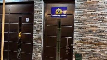 Dos puertas con un muro de piedra de fondo y un cartel que indica un centro de traslados VIP.
