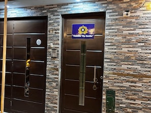 Dos puertas con un muro de piedra de fondo y un cartel que indica un centro de traslados VIP.