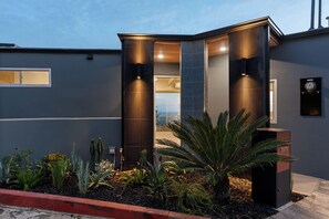 Un bâtiment moderne à la façade sombre, doté d’une entrée en verre et d’un foyer situé sur le côté droit.