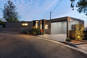 A modern two-story house with a garage, a driveway, and a well-maintained lawn. - Iconic Hollywood Panoramic Perch (Los Angeles)
