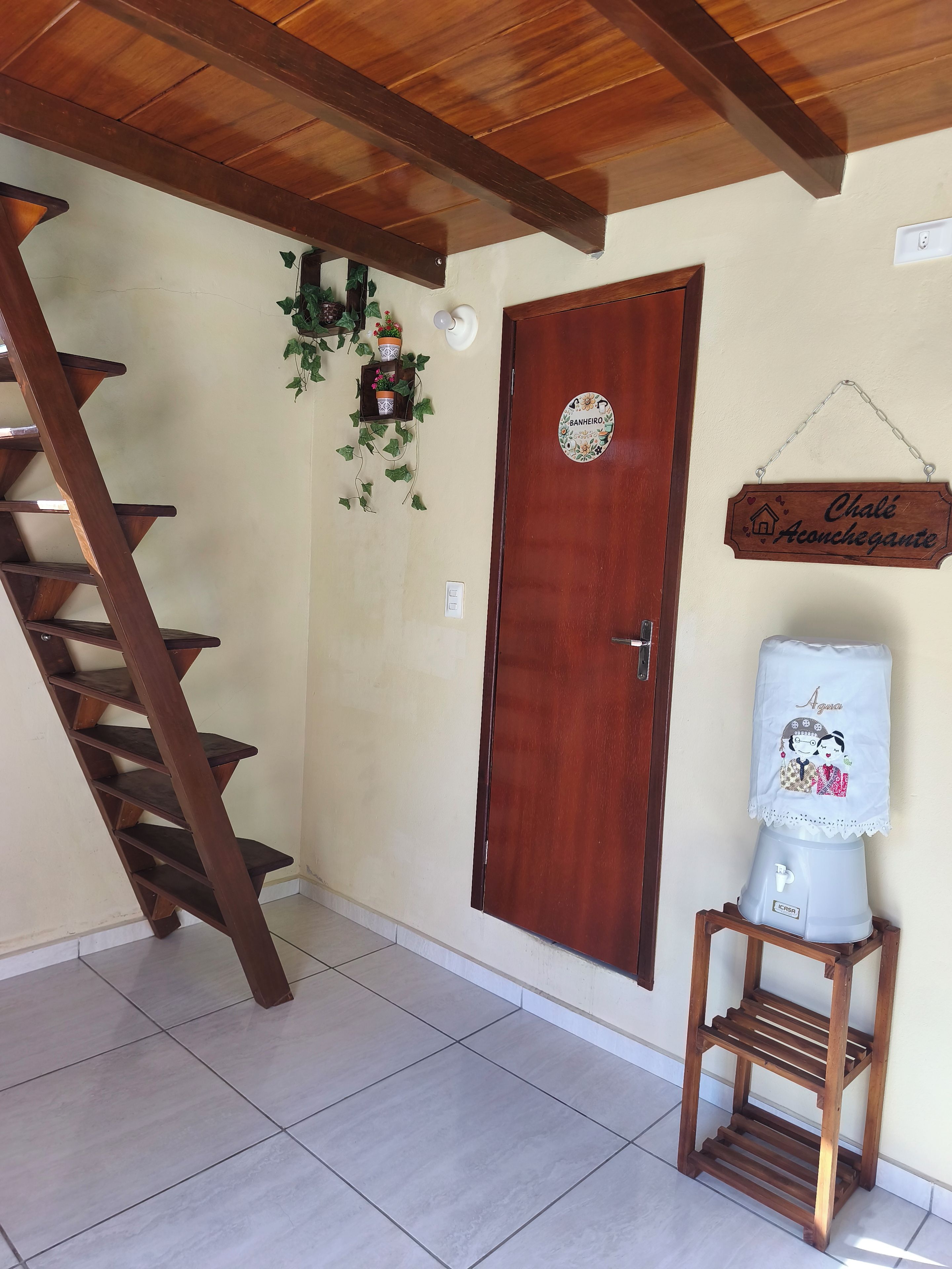 A wooden staircase, a door with a sign, a small shelf, and a water dispenser.