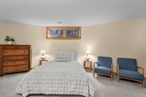 A bedroom with a bed, two nightstands, a dresser, a chair, and a window. - Riverfront Ski Cabin W/ Hot Tub & Dock! (Bend)