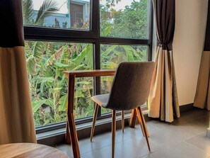 Ein Zimmer mit Fenster, Stuhl und Tisch.