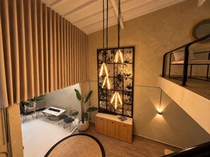 Ein modernes Interieur mit Essbereich, einem Holzkabinett und einer wandmontierten Leuchte.