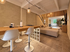 Eine moderne Küche mit einer Holz Arbeitsplatte, Barhocker und einem eingebauten Herd.