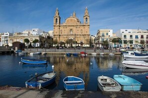Ein Hafen mit vertäuten Booten und einer markanten Kirche im Hintergrund.