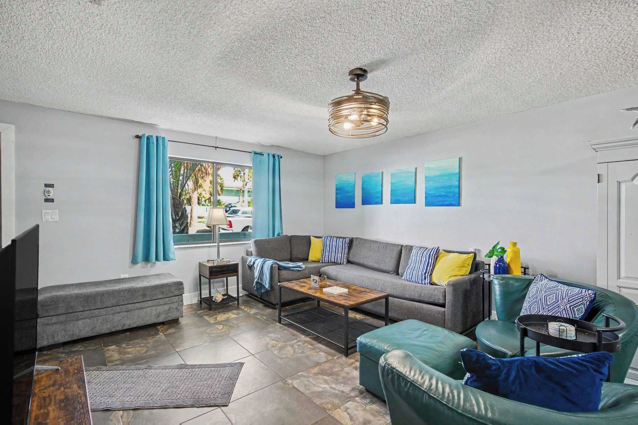 A modern living room with a sectional sofa, a coffee table, and a green armchair.