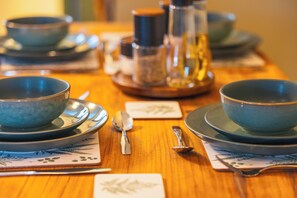 A table set with blue bowls, spoons, and a pitcher, suggesting a dining arrangement.