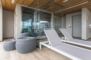 A modern waiting area with glass walls, a wooden ceiling, and lounge chairs. - New Studio w/ Parking near República Metro DR1208 (República)