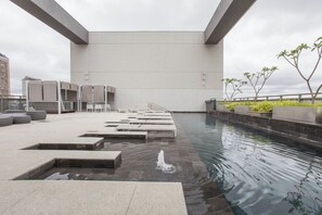 A rooftop pool area with a clear view of the sky, a water feature, and a seating area with steps leading into the pool. - New Studio w/ Parking near República Metro DR1208 (República)