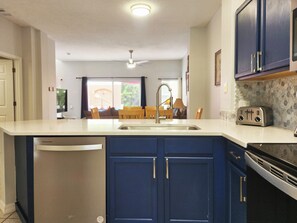 Een keuken met een inbouwvaatwasser, een broodrooster en een eethoek met een tafel en stoelen.