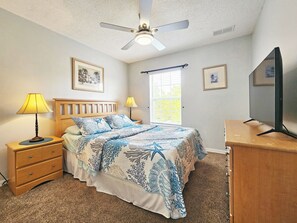 A bedroom with a bed, a nightstand, a desk, a ceiling fan, and a window with blinds. - Charming 3-bedroom townhome with AC in fantastic Kissimmee (Kissimmee)