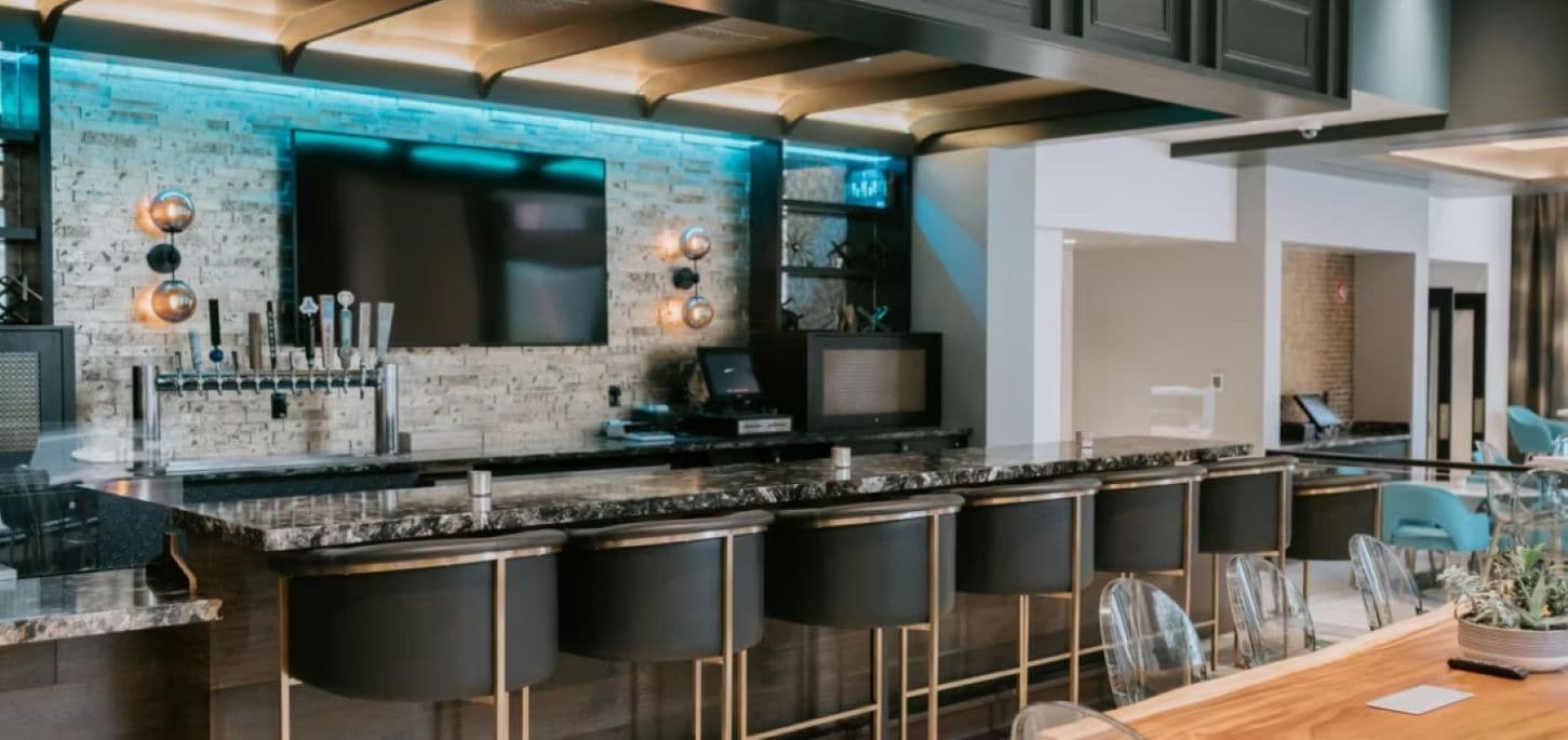 Cuina moderna amb zona de bar, televisió de pantalla plana i seients.