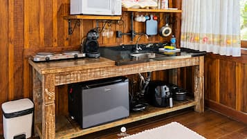 Een praktische keuken met een magnetron, koffiezetapparaat en een kleine koelkast.