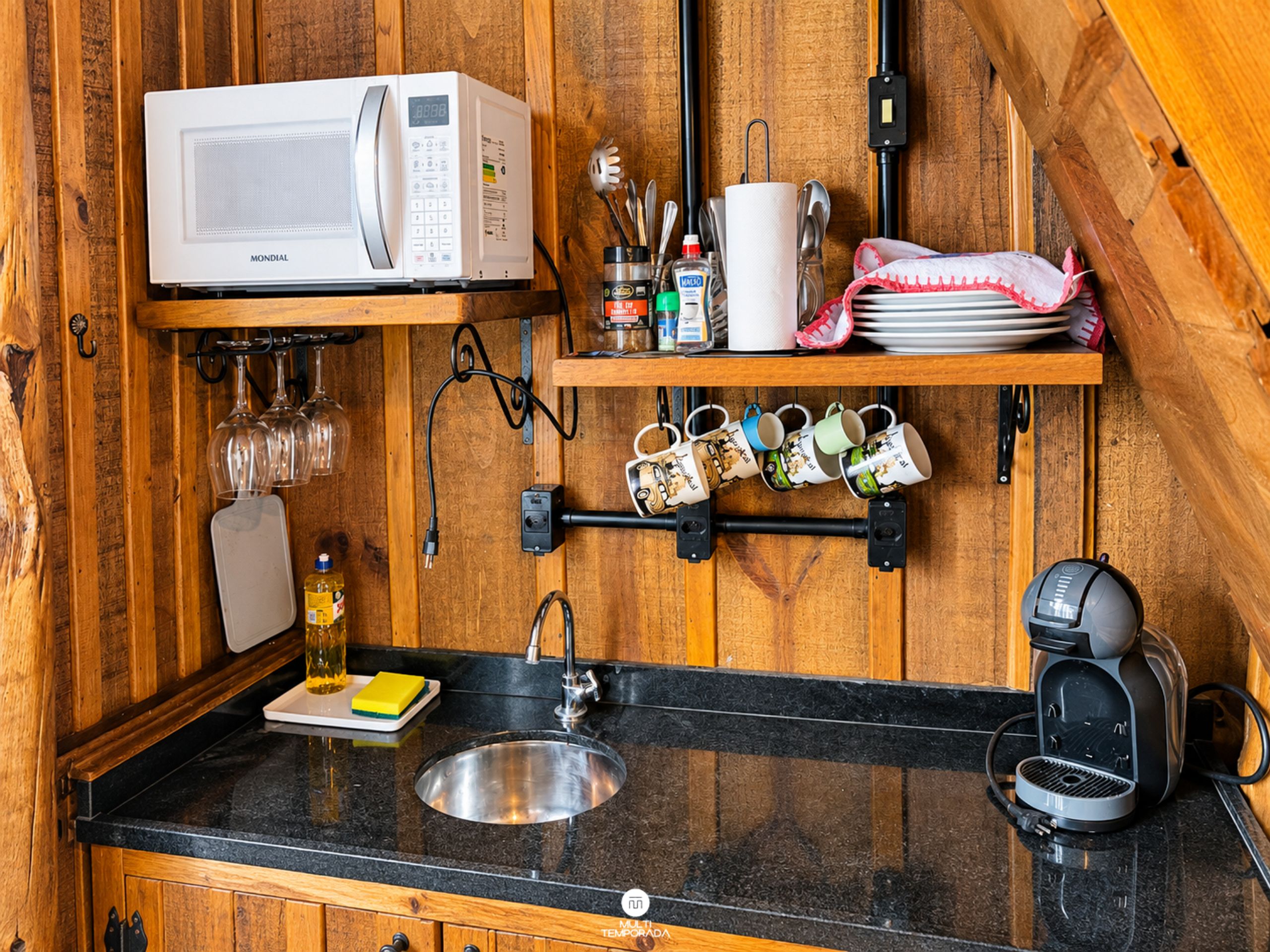 Una cocina compacta con microondas, cafetera y lavabo.