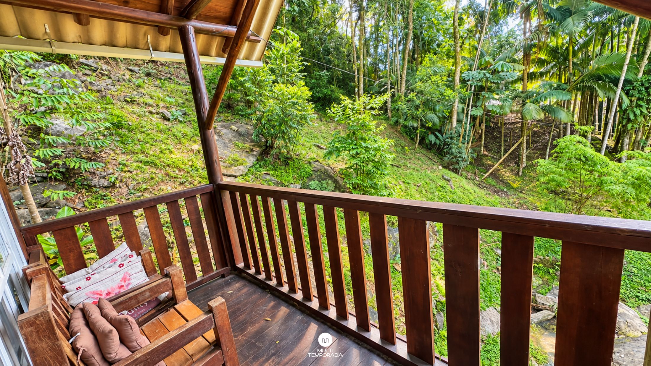 Une terrasse en bois offrant une vue sur une forêt verdoyante et luxuriante.