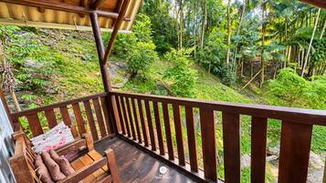 Une terrasse en bois offrant une vue sur une forêt verdoyante et luxuriante.