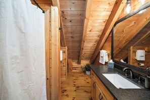 A narrow wooden bathroom with a sink, mirror, and towel rack. - The Nook - Mountain Views - Hot tub  - Dogs  - Hiking (Blue Ridge)